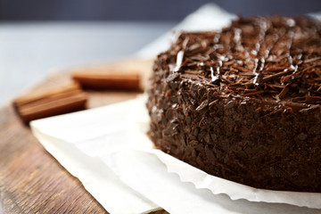 Tasty chocolate cake on color wooden background