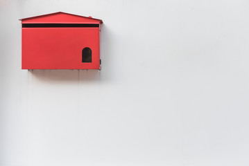 red mailbox on old white wall