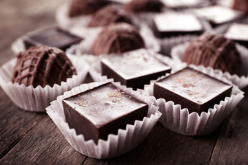 Assorted chocolate candies on wooden background