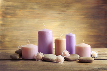 Obraz na płótnie Canvas Spa set with candles, pebbles and flowers on wooden background