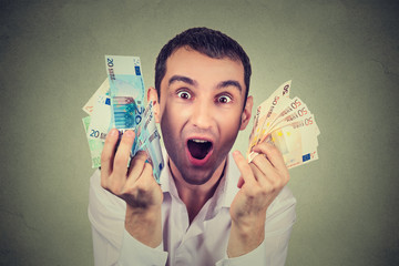 happy young man with money euro banknotes ecstatic celebrates success