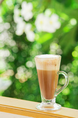 coffee with pattern in a white cup on wooden background