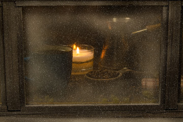 Winter window. Cozy room. Candlesticks on a windowsill. Coffee Cup and roasted coffee beans.
