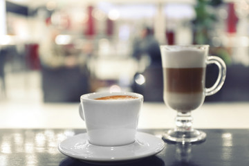 Cup of coffee and tasty latte on the table in the cafe, close up