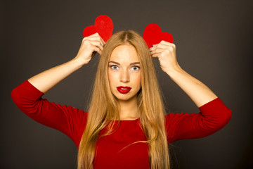 young woman with red hearts in the studio on a dark background