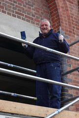 A painter and decorator working from a scaffold tower