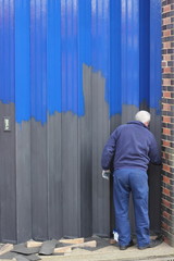 Obraz premium A painter and decorator painting industrial bi-folding doors