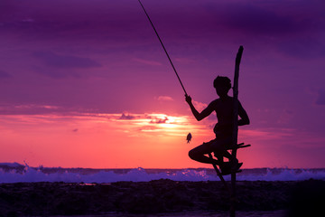 Silhouette of stilt fisherman at sunset in Koggala, Sri Lanka