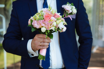 Beautiful wedding bouquet in rustic style in the grooms hands