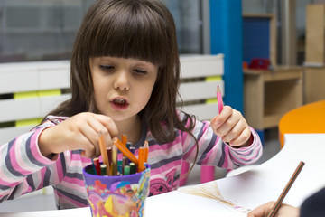 Little girl drawing at playroom