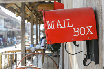 red mail box on wooden wall