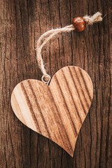 Wooden heart on natural background with a string