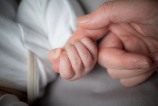 Close up mother's hand holding baby