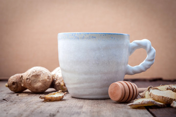 Cups of herbal tea with ginger and honey on wooden background.