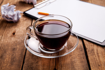 Crumpled paper balls with pencil and clipboard on wooden background, cup of coffee, a wrong idea, business concept