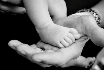 Baby's foot in grandfather's hand
