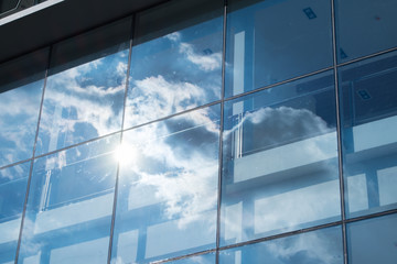 Fototapeta na wymiar Sun ray and blue sky reflection on window office building, Busin
