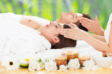 Obraz na płótnie Canvas Relaxed Couple Receiving Head Massage At Spa