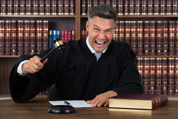 Angry Judge Striking His Gavel At Table