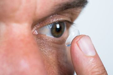 Closeup Of Man Putting Contact Lens In Eye