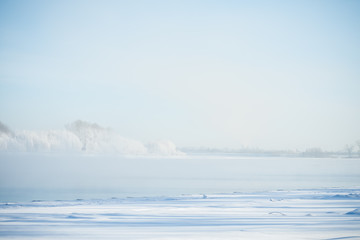 The frozen river and trees in hoarfrost
