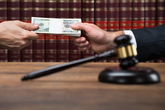 Gavel On Table With Judge Taking Bribe From Businessman