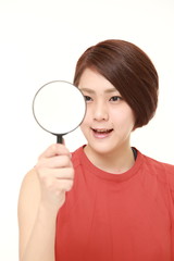 young Japanese woman with a magnifying glass 