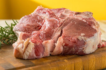 Bistecca alla  fiorentina cruda sul tagliere di legno con rametti di rosmarino