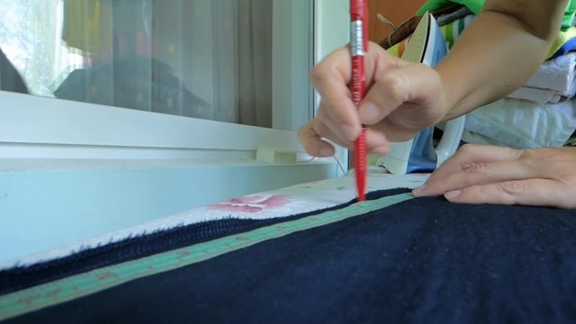 The tailor makes marks on the fabric