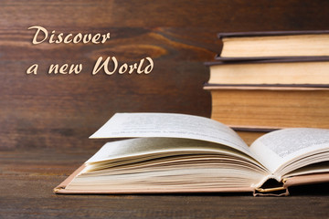 the book with the colored cover lay open on a wooden table text