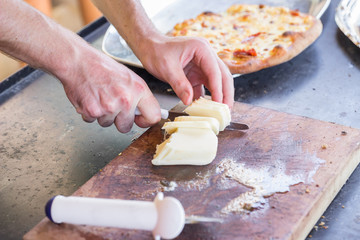 Man cutting cheese cooking pizza