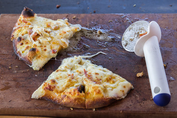 Homemade pizza pieces on wooden cutting board