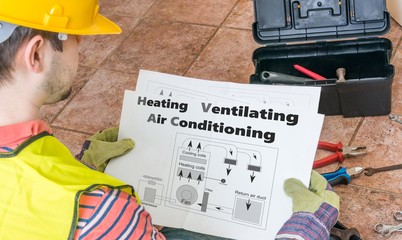 Repairman is looking at documentation of HVAC (Heating, Ventilating, Air Conditioning)