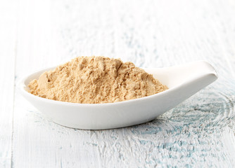 Maca powder in white porcelain spoon