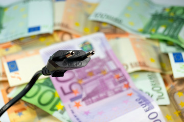 Ein Stromstecker und Bargeld