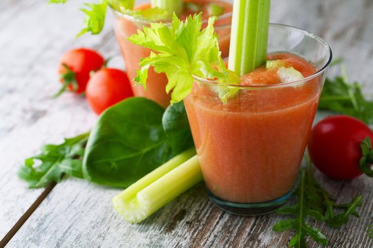 Fresh smoothies tomato and celery on a  wooden background