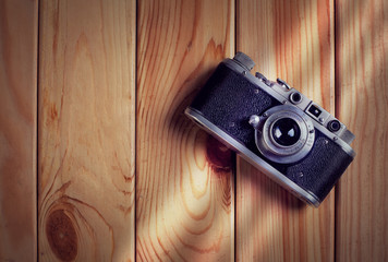 Vintage film camera on wooden table. Top view with copy space