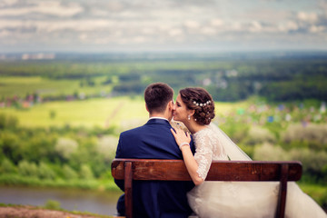wedding Bride and groom on a bench with nature landscape scenery