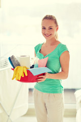happy woman holding cleaning stuff at home