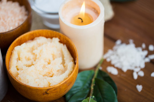 Close Up Of Natural Body Scrub And Candle On Wood