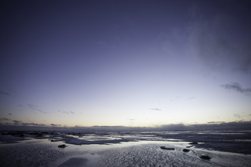 Fototapeta na wymiar snowfield and water scenery of early spring on big lake