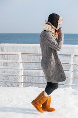 portrait of young attractive woman with scarf on winter beach