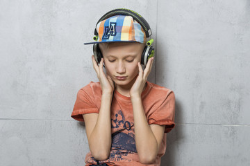 Zasłuchany w muzykę chłopiec w słuchawkach - obrazy, fototapety, plakaty