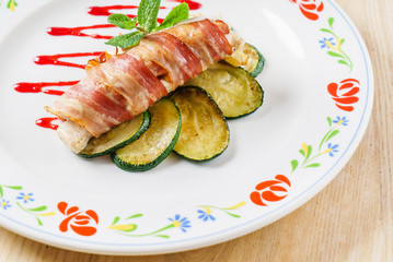 chicken roll wrapped in strips of bacon