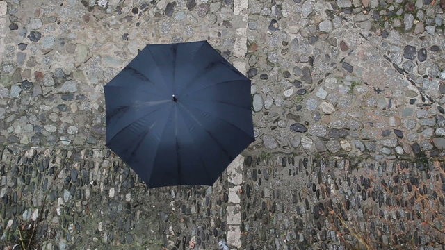 Black Umbrella in Rotation up View in the Street