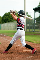 Youth baseball boy swinging bat