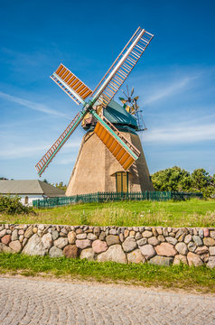 Traditional windmill in beautiful scenery with blue sky and clouds