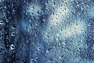 Raindrops on a window on a cold winter day, natural background,