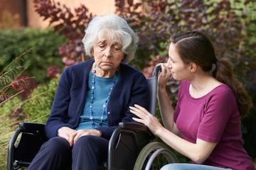 Plakat Adult Daughter Comforting Senior Mother In Wheelchair