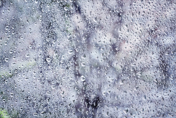 Raindrops on a window on a cold winter day, natural background,